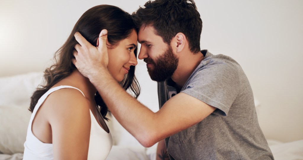 View of a young loving couple sharing a romantic moment in the bedroom at home